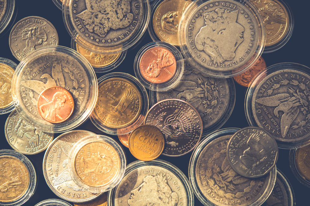 Collection of mixed rare silver and gold coins in protective cases, assessed by Coin Buyers in College Station.