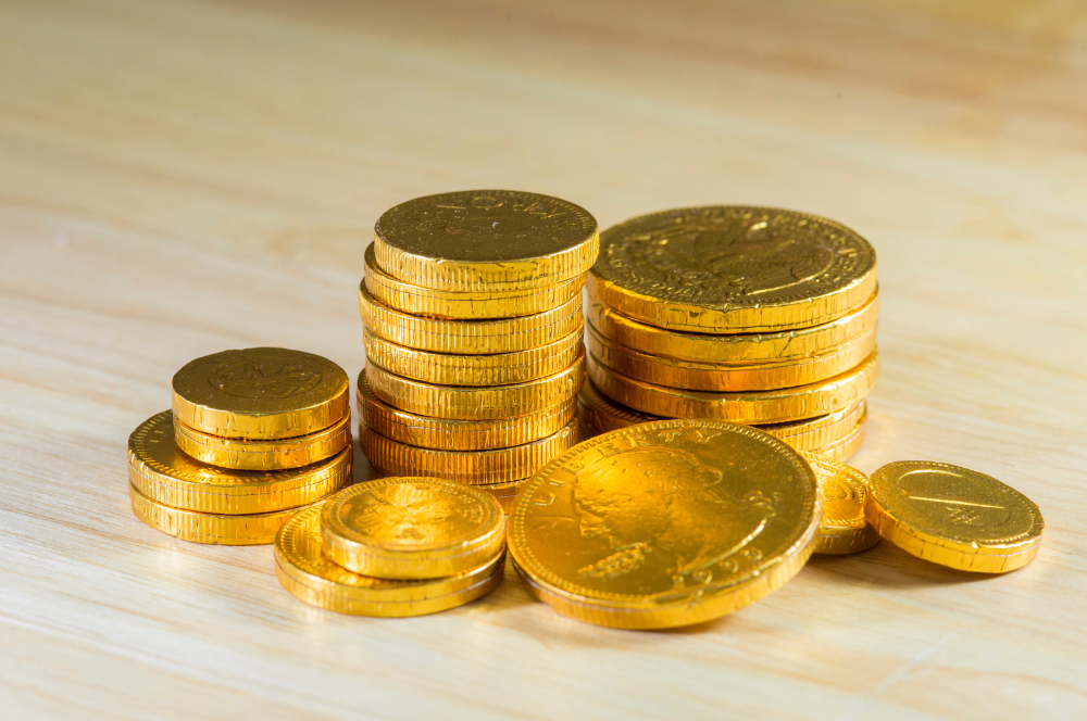 Stacks of gold coins displayed on a wooden surface, ready for appraisal by Coin Buyers in College Station.